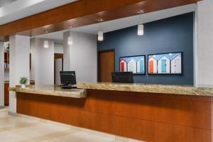 an office lobby with a reception desk with a painting on the wall at Hyatt House Fort Lauderdale Airport/Cruise Port in Dania Beach
