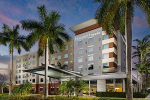 a hotel with palm trees in front of it at Hyatt House Fort Lauderdale Airport/Cruise Port in Dania Beach