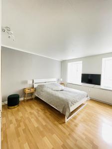 1 dormitorio blanco con 1 cama y TV de pantalla plana en aday - Central Studio Apartment en Aalborg