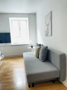 sala de estar con sofá y ventana en aday - Central Studio Apartment, en Aalborg