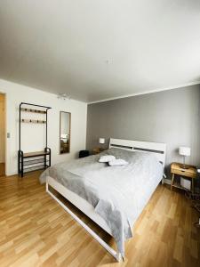 1 dormitorio con 1 cama blanca grande y suelo de madera en aday - Central Studio Apartment en Aalborg
