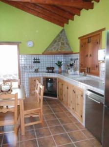 een keuken met een tafel en een wastafel en een tafel en stoelen bij Casa costera playa de Tasarte in San Nicolás