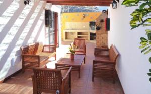 een patio met houten stoelen, een tafel en banken bij Casa costera playa de Tasarte in San Nicolás +19 foto's