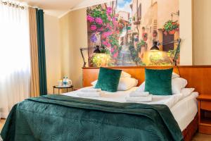 a bedroom with a bed with a painting on the wall at Hotel Wenecki in Częstochowa +32 photos