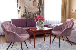 salon z 2 krzesłami i wazonem kwiatów na stole w obiekcie Hotel Wenecki w mieście Częstochowa