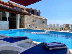 una piscina con 2 sillas de césped y una piscina en Villa Vera Mlini en Mlini