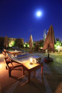 um pátio com mesas e guarda-sóis à noite em Riad Al Ksar & Spa em Marrakech