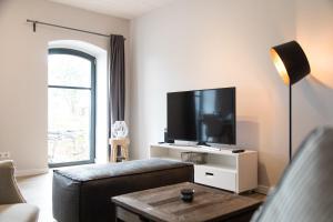ein Wohnzimmer mit einem Sofa und einem Flachbild-TV in der Unterkunft Gulfhof Dreybült Dreybült 10 Wilko in Dornum