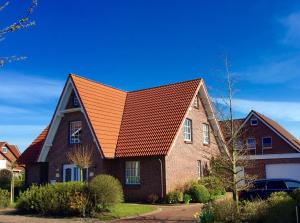 an orange roof on a brick house at Ferienhaus Canvas Canvas Carolinensiel FeWo "Wangerooge" in Wittmund