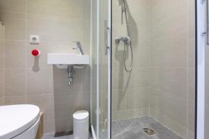 a bathroom with a shower with a toilet and a sink at Studio with a panoramic view at the last floor of the residence with a pool in Antibes