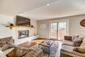 sala de estar con sofá y chimenea en Classy Lakefront Home with Charcoal Grill and Deck! en Prospect Heights
