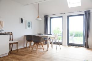 - une cuisine et une salle à manger avec une table et des chaises dans l'établissement Gulfhof Polder72 Polder72 9 Hikka, à Dornum