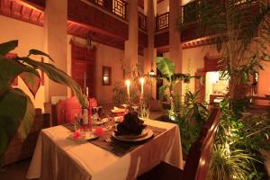a dining table in a room with plants at Riad Al Ksar & Spa in Marrakesh