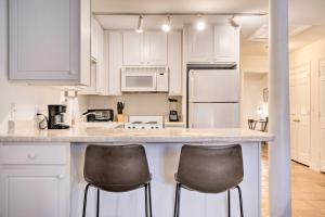 Una cocina con gabinetes blancos y dos taburetes de bar. en Ideally Located and Updated Chapel Hill Apartment!, en Chapel Hill 16 fotos más