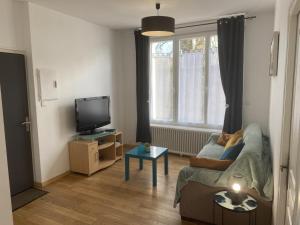 a living room with a couch and a tv at La Marina 2 in Étaples