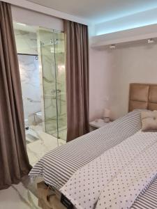 a bedroom with a bed and a glass shower at Liga apartment in Vračar (historical)