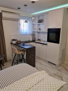 a white kitchen with a table and a counter at Liga apartment in Vračar (historical)