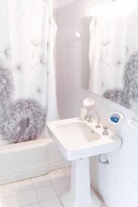 a white bathroom with a sink and a shower at El Nido Hostel in San Rafael