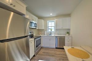 a kitchen with white cabinets and a stainless steel refrigerator at Welcoming Wildwood Condo about 1 Block to Beach! in Wildwood