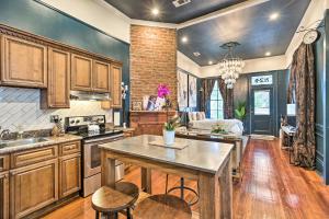a kitchen with wooden cabinets and a table in it at Walk to Magazine Street Contemporary NOLA Studio in New Orleans