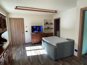 ein Wohnzimmer mit einem Sofa und einem Flachbild-TV in der Unterkunft Casa Carral in Aymavilles