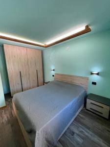 1 dormitorio con cama y pared azul en Casa Carral, en Aymavilles