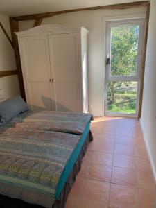 a bedroom with a bed and a large window at Majellon Grand Appartement in Sainte-Christie-dʼArmagnac