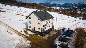 a building with cars parked next to a ski slope at Willa Monte in Wisła