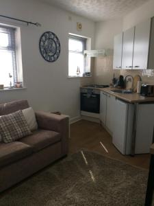 a living room with a couch and a kitchen at Lovely little flat by the sea in Cleethorpes in Cleethorpes