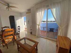 een woonkamer met een tafel en uitzicht op de oceaan bij Apartamento en zona nudista Vera Almería - Oso House in Vera