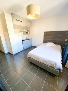 a bedroom with a large bed and a kitchen at City Résidence Nice in Nice