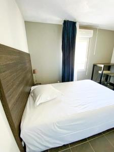 1 cama blanca grande en una habitación con ventana en City Résidence Nice en Niza