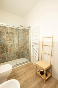 ein Badezimmer mit einer Dusche, einem WC und einem Stuhl in der Unterkunft BORGOROMA - Business & Home in Verona