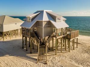 a house on stilts on the beach at Strand Castle - GULF FRONT! An ideal layout with game room, small private pool, and roof top crow's nest! home in Dauphin Island