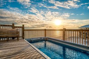 a swimming pool on a deck with a bench at Strand Castle - GULF FRONT! An ideal layout with game room, small private pool, and roof top crow's nest! home in Dauphin Island