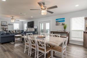 a dining room and living room with a table and chairs at Strand Castle - GULF FRONT! An ideal layout with game room, small private pool, and roof top crow's nest! home in Dauphin Island