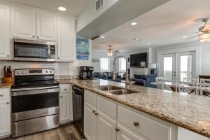 a kitchen with a sink and a stove top oven at Strand Castle - GULF FRONT! An ideal layout with game room, small private pool, and roof top crow's nest! home in Dauphin Island