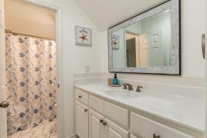 a bathroom with a sink and a mirror at Strand Castle - GULF FRONT! An ideal layout with game room, small private pool, and roof top crow's nest! home in Dauphin Island
