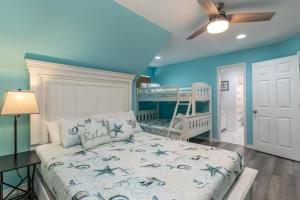a bedroom with a bed and a bunk bed at Strand Castle - GULF FRONT! An ideal layout with game room, small private pool, and roof top crow's nest! home in Dauphin Island