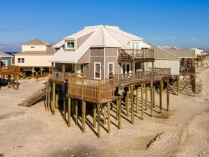 a house on a pier on the beach at Strand Castle - GULF FRONT! An ideal layout with game room, small private pool, and roof top crow's nest! home in Dauphin Island