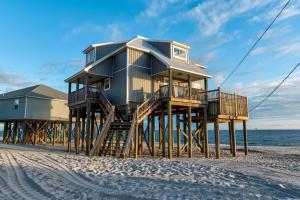 a house on wooden posts on the beach at Strand Castle - GULF FRONT! An ideal layout with game room, small private pool, and roof top crow's nest! home in Dauphin Island