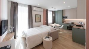 a bedroom with a white bed and a kitchen at Residence Casa Coppa Appartamento Flox in Omegna