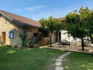 a house with a table and chairs in a yard at Majellon Grand Appartement in Sainte-Christie-dʼArmagnac