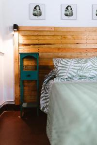 a bed with a wooden headboard and a blue night stand at El Nido Hostel in San Rafael