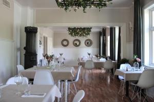 a restaurant with white tables and chairs and a chandelier at Petrines Gjestgiveri in Norddal