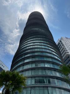吉隆坡的住宿－Vortex Suites KLCC by Luna，一座高大的建筑,前面有棕榈树