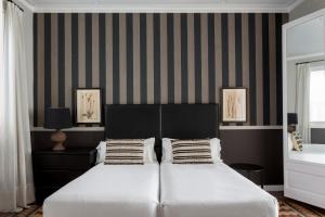 Dos camas en un dormitorio con paredes rayadas. en Barcelona Apartment Val, en Barcelona 41 fotos más