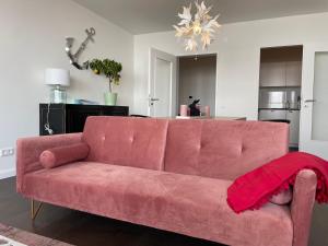 a pink couch with a red blanket on it in a living room at Weser-Traum in Bremerhaven