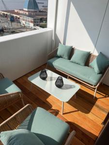 a balcony with two couches and a table and a window at Weser-Traum in Bremerhaven