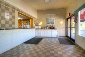 a kitchen with white cabinets and a tile floor at Corbin Inn in Corbin